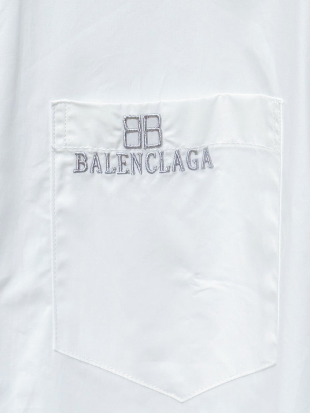 White chest pocket of long-sleeve button-up shirt with Balenciaga logo embroidery
