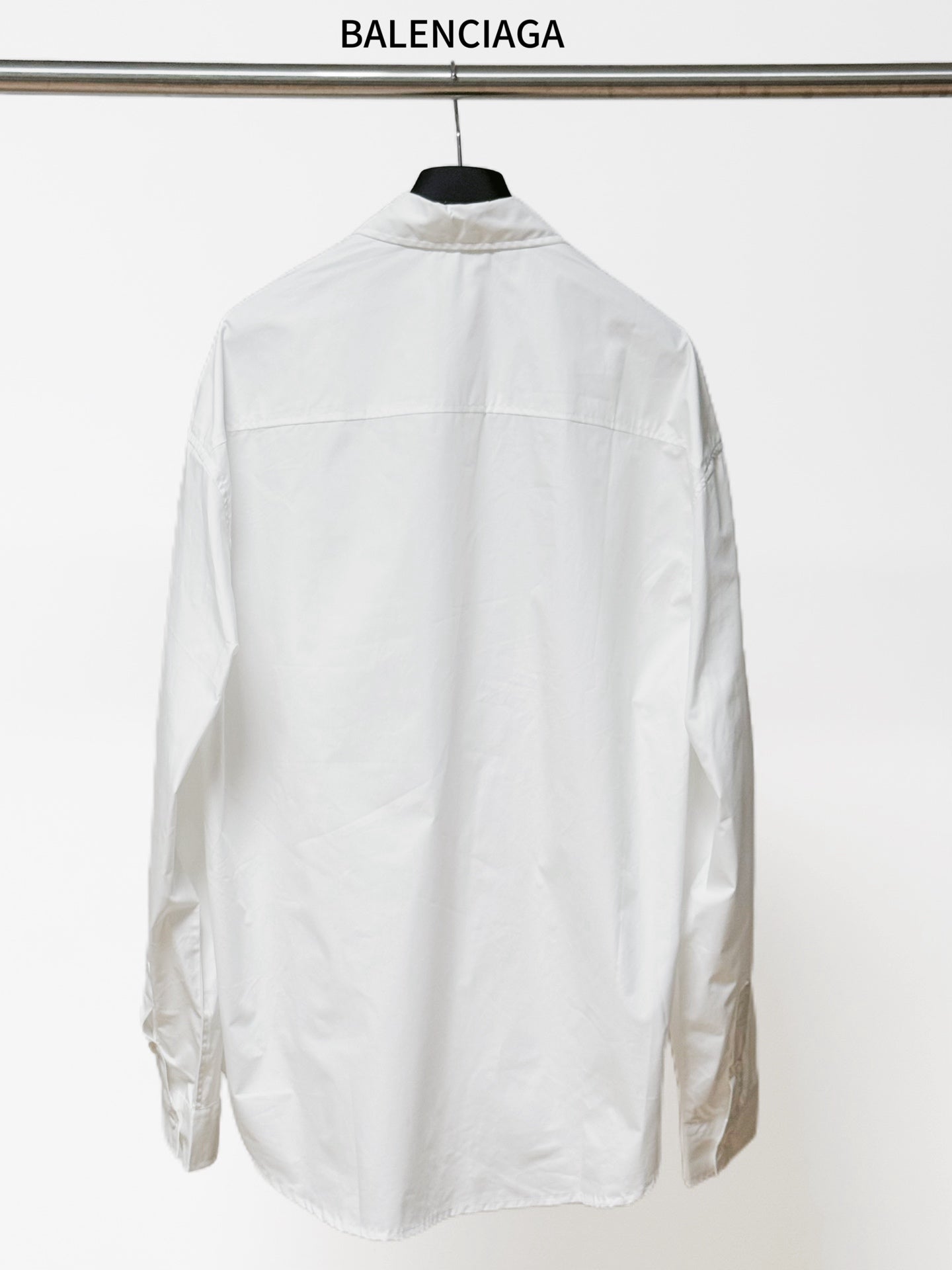 White long-sleeve button-up shirt, back view with yoke seams and logo detail