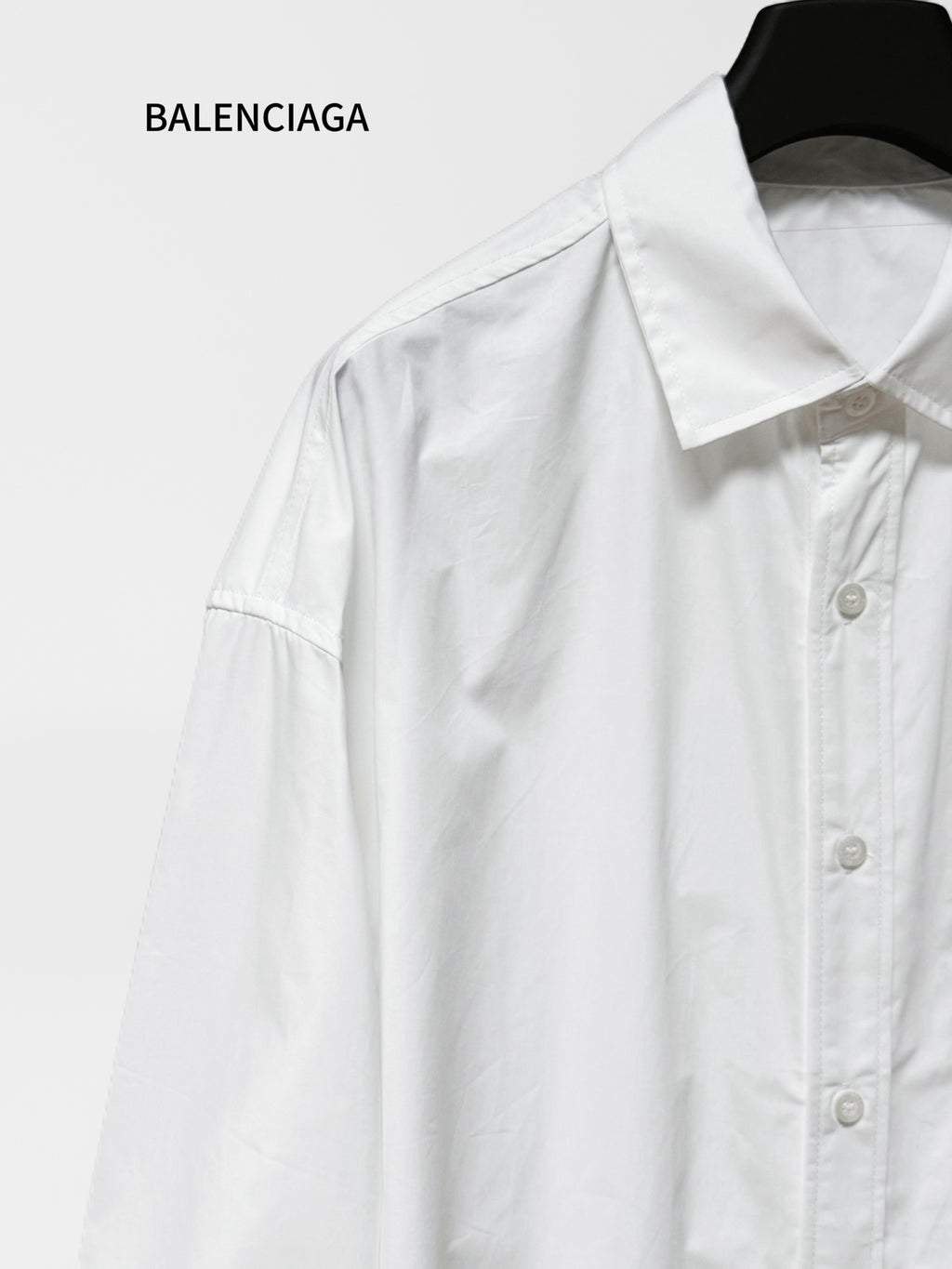 White long-sleeve button-up shirt with pointed collar and visible button placket