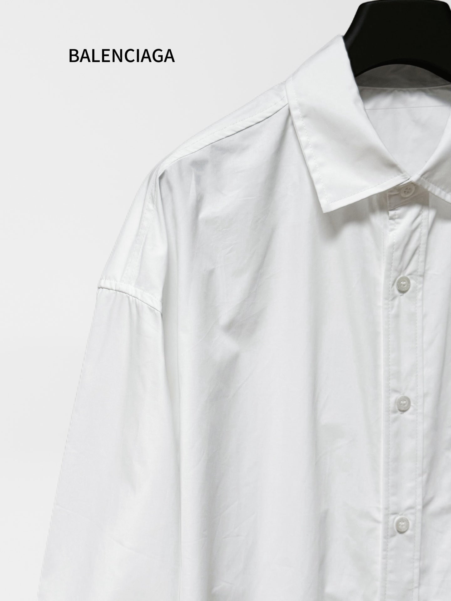 White long-sleeve button-up shirt with pointed collar and visible button placket