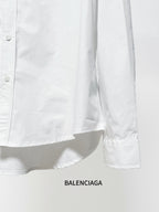 White long-sleeve button-up shirt lower side with curved hem and cuff edge