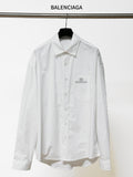 White long-sleeve button-up shirt with pointed collar and chest logo patch