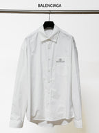 White long-sleeve button-up shirt with pointed collar and chest logo patch