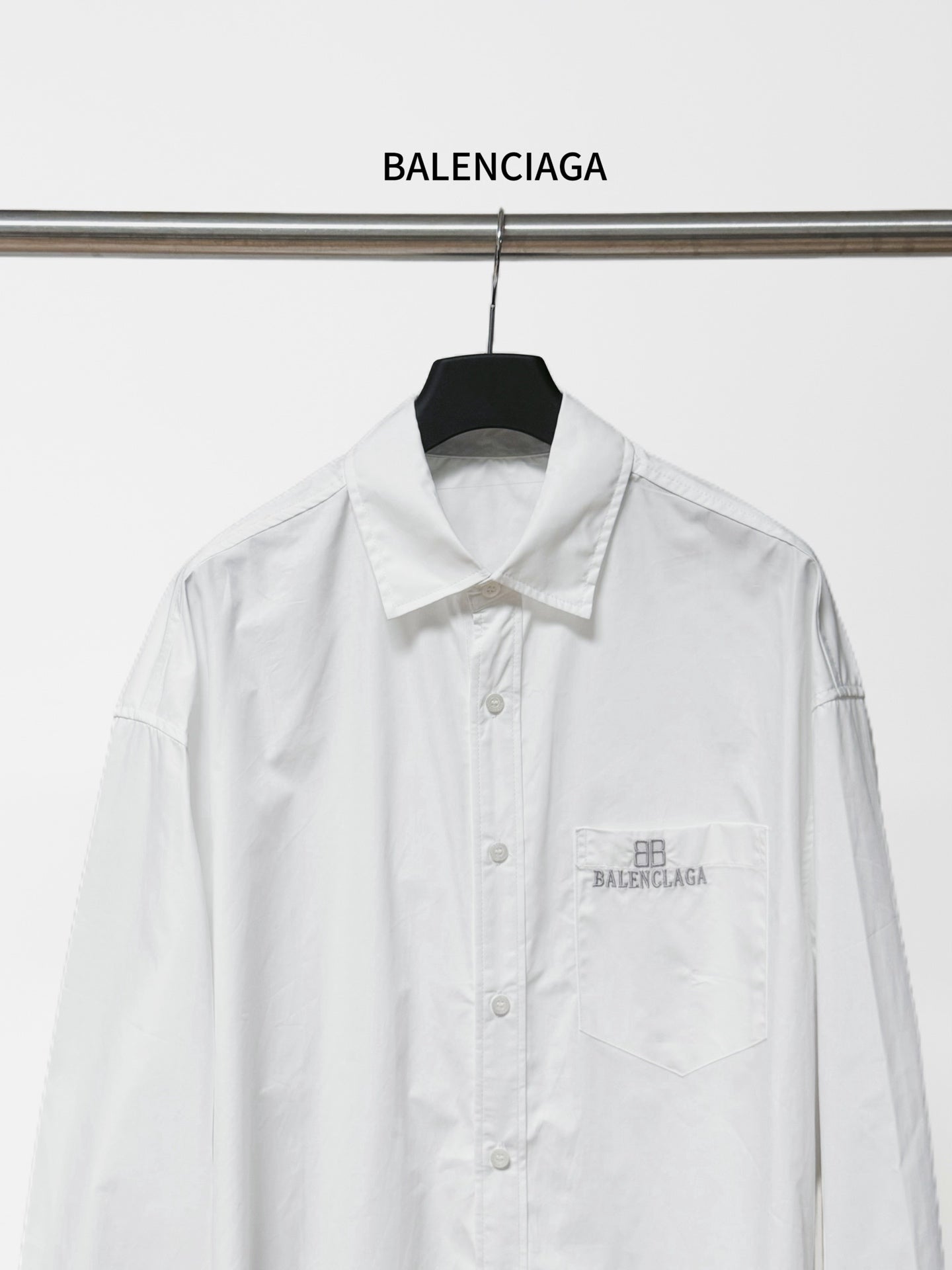 White long-sleeve button-up shirt front view with chest pocket and Balenciaga logo