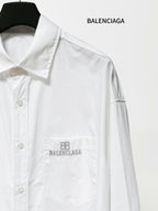 White long-sleeve button-up shirt close-up of chest pocket with Balenciaga embroidery