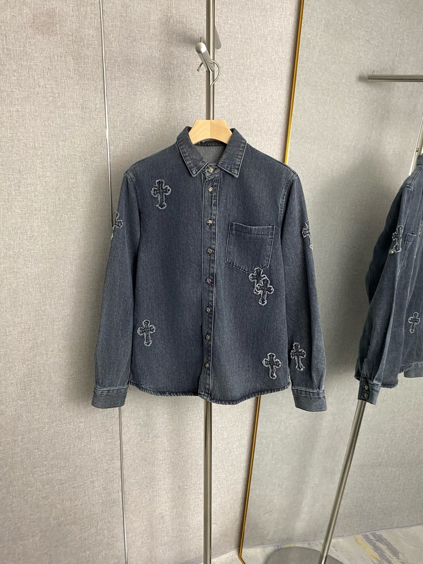 Dark blue denim jacket with button front and embroidered cross icons