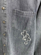 Dark blue denim chest pocket with embroidered cross detail