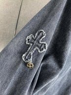 Denim jacket shoulder with embroidered cross patch and gold-toned button