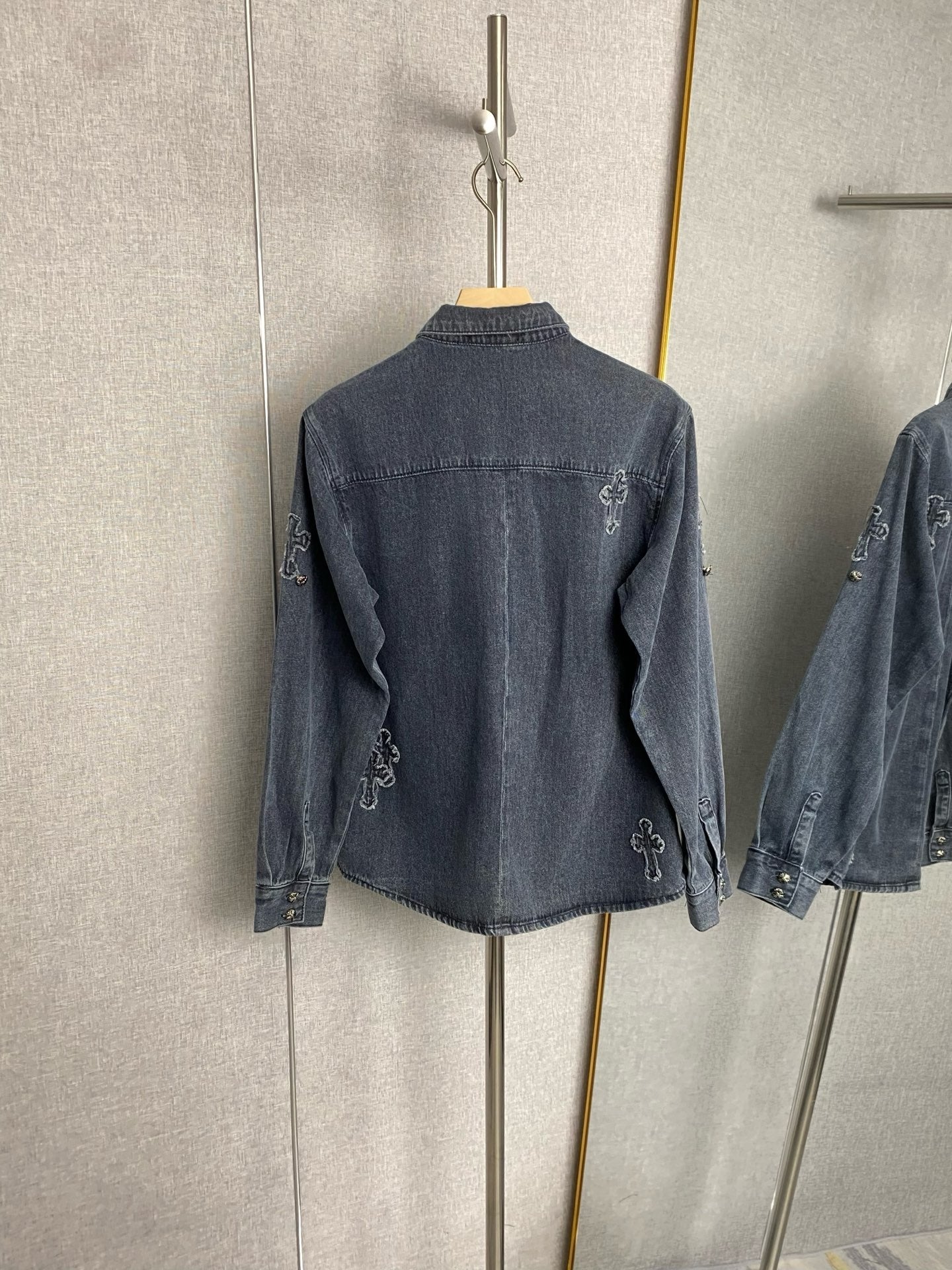 Dark blue denim jacket back view with embroidered cross motifs and stand collar