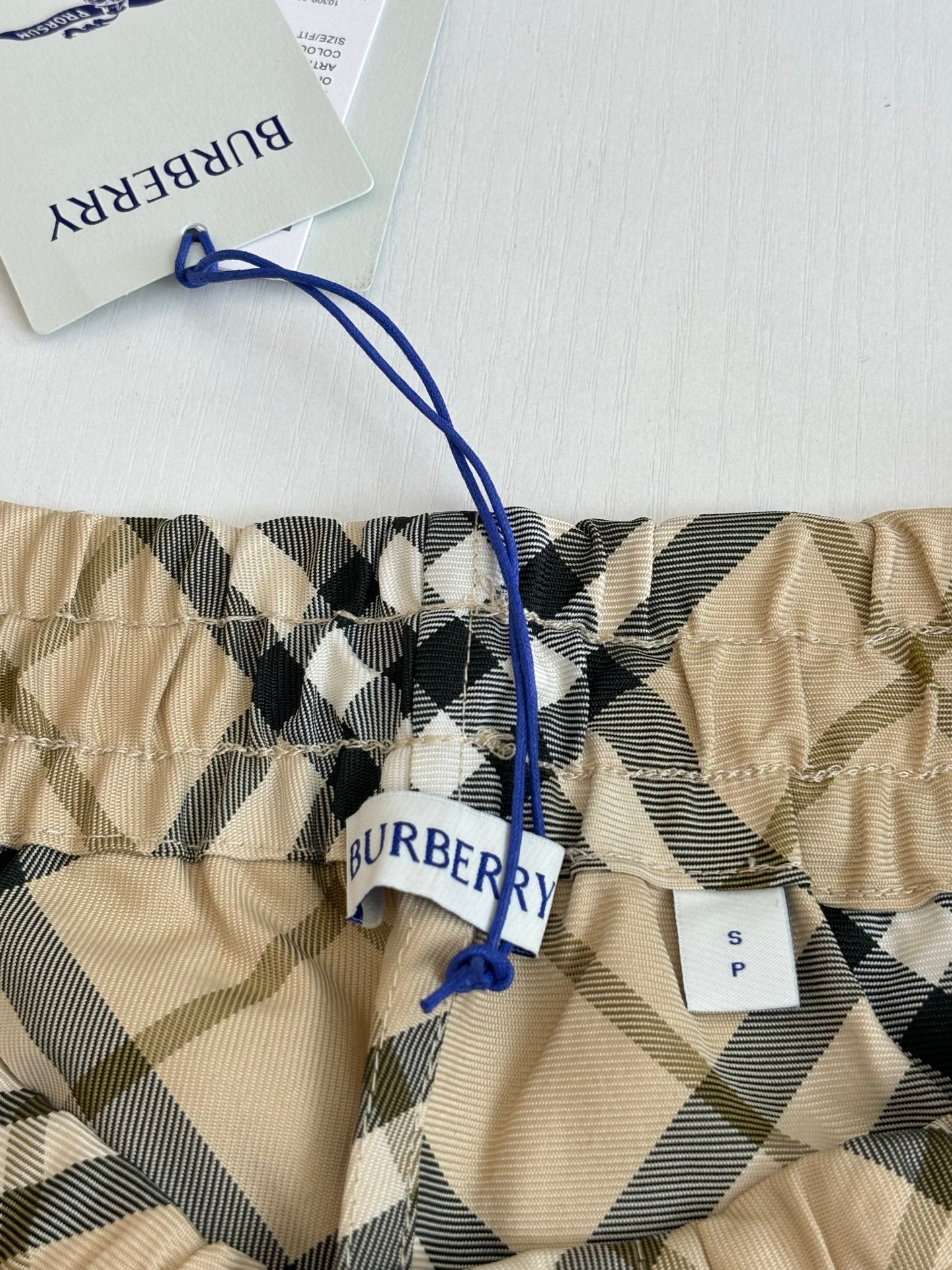Burberry check pants with blue drawstring waist and fabric tag detail