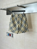 Burberry plaid shorts on hangers, elastic waistband and drawstring ties at center.