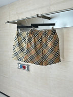Burberry plaid shorts on hanger, elastic waistband and front drawstring detail visible.