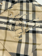 Burberry plaid shorts embroidery patch detail on beige and black check fabric.