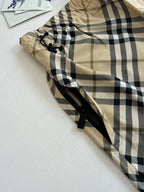 Burberry plaid shorts fabric detail, beige and black check with drawstring and tie.
