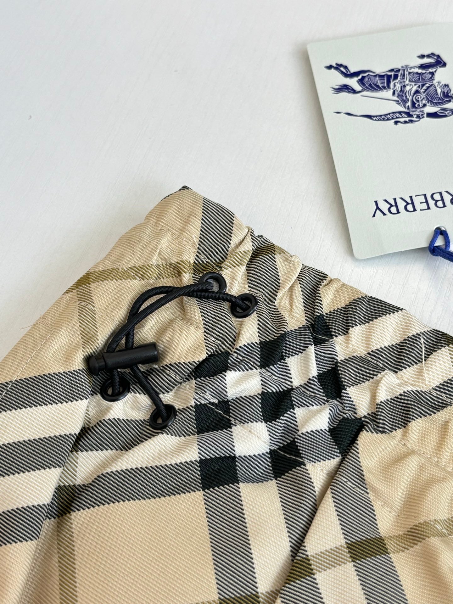 Burberry plaid shorts close-up of elastic waistband and black drawstring ties.
