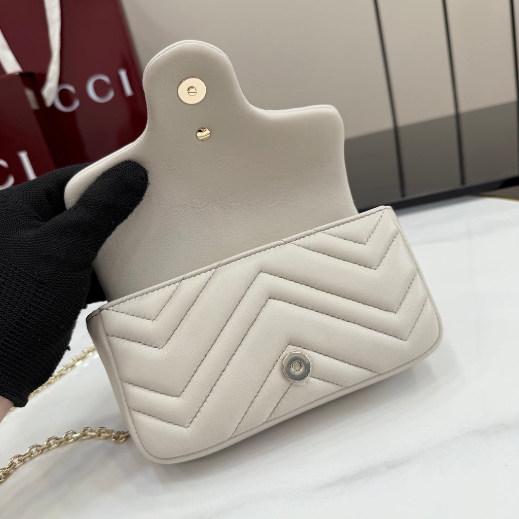 White quilted mini shoulder bag with small turn-lock logo and gold chain strap