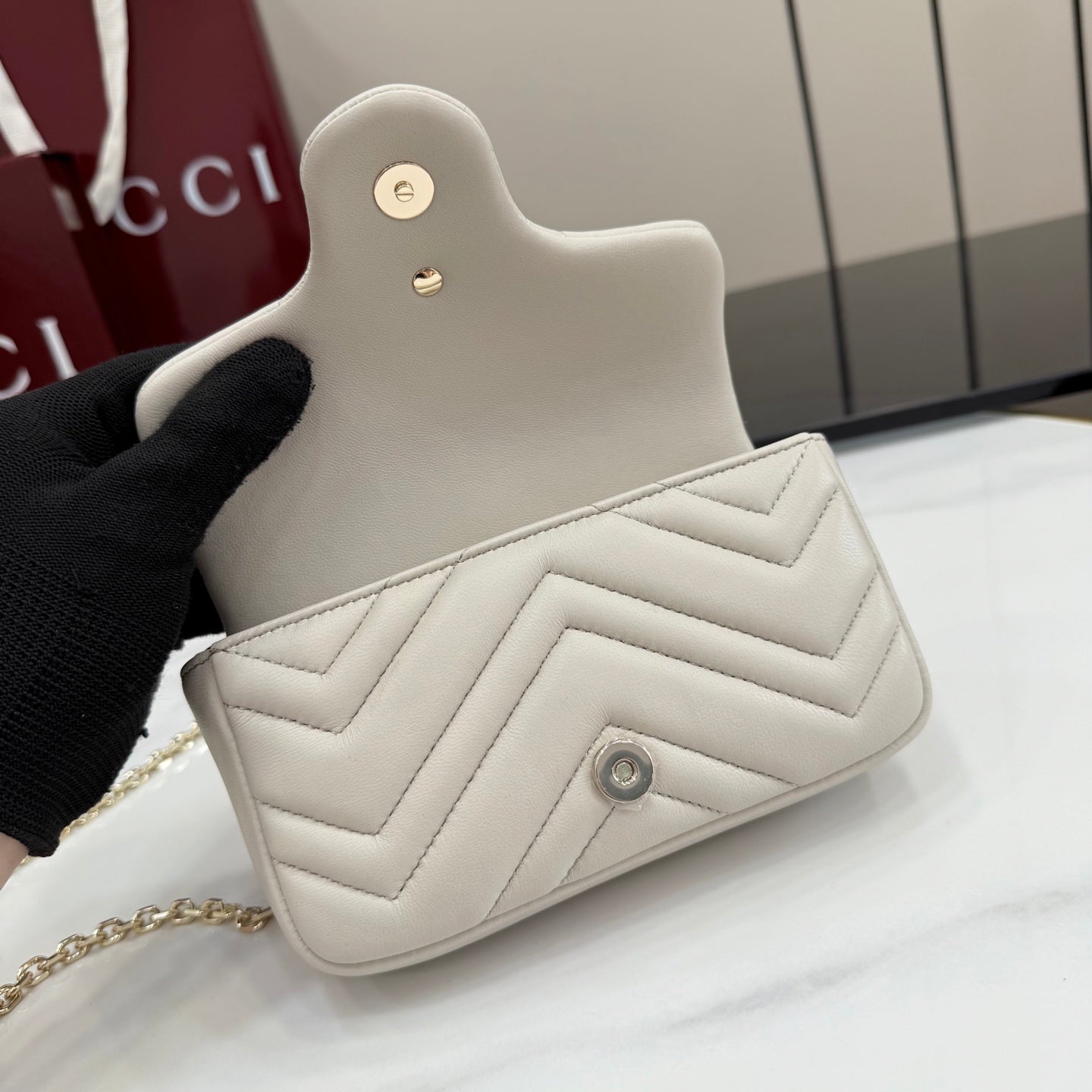 White quilted mini shoulder bag with small turn-lock logo and gold chain strap