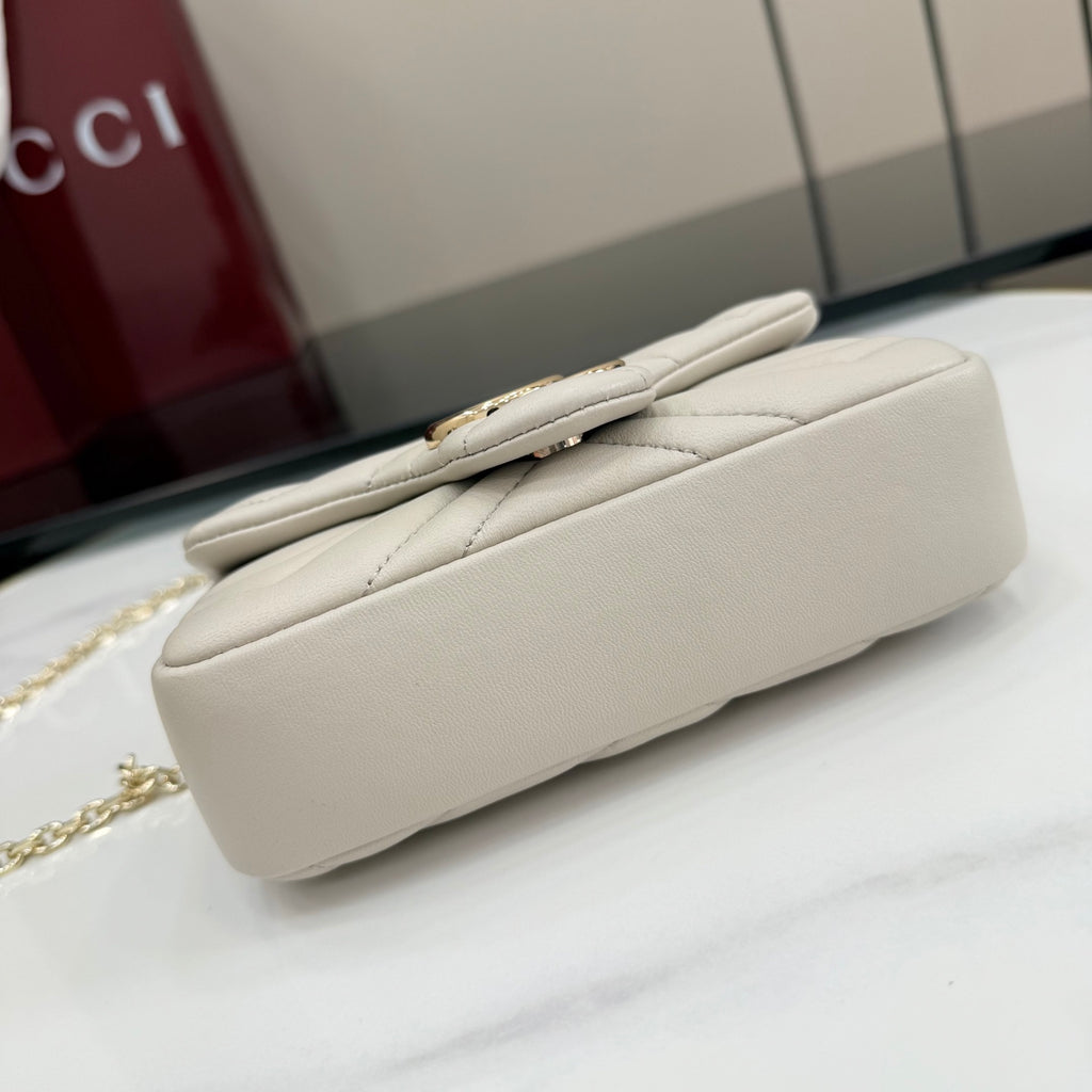 White leather shoulder bag side profile with smooth trim and quilted stitching