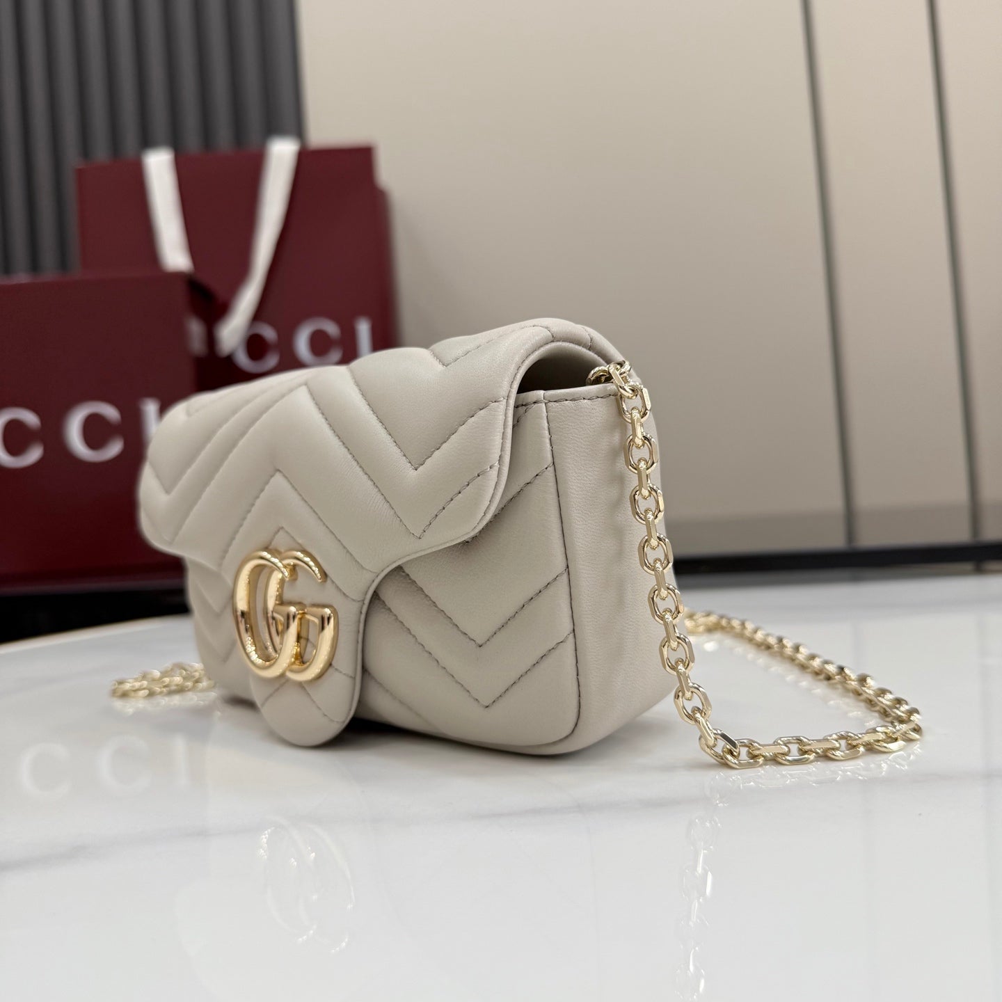 Small quilted shoulder bag with chevron stitching and chain strap, light color