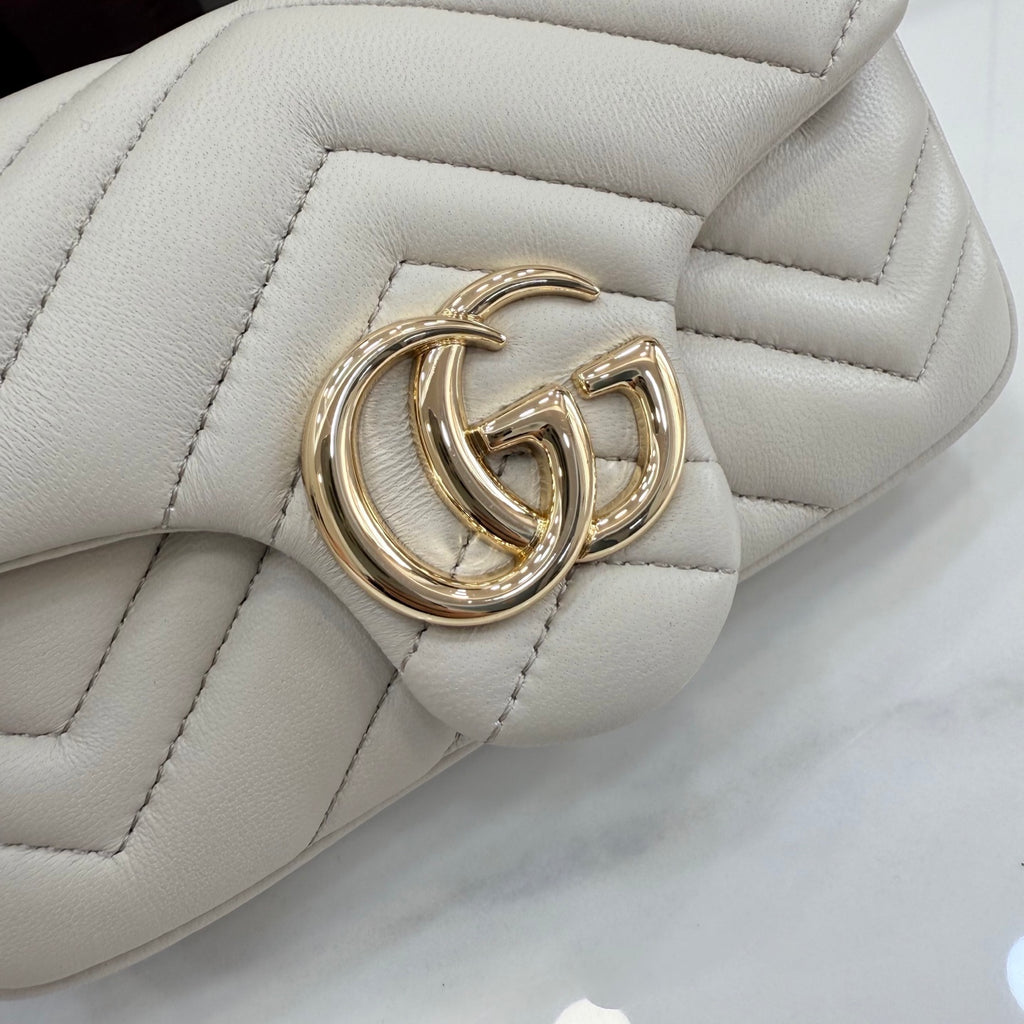 Gold-tone double G clasp on white quilted shoulder bag