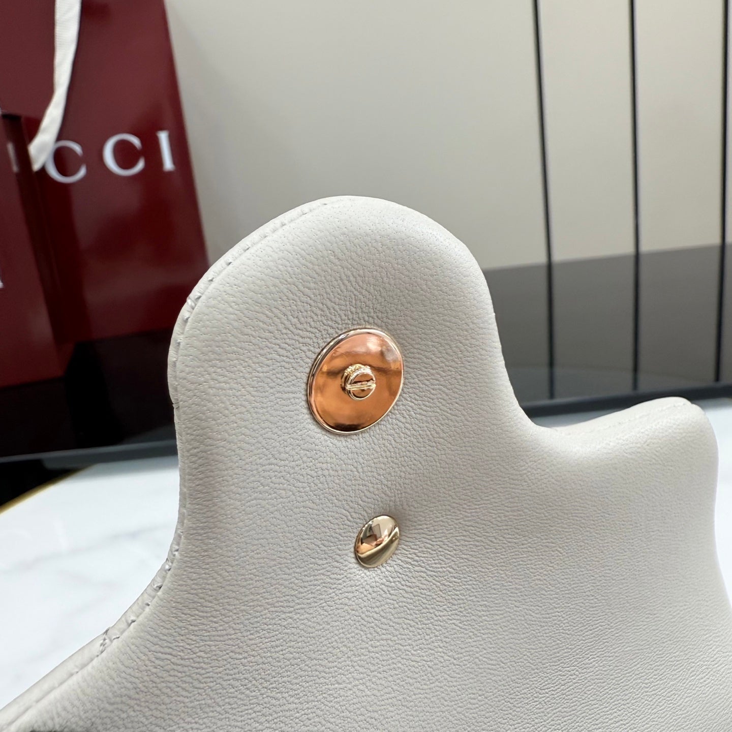 Small leather shoulder bag with round gold-tone hardware on back in light color