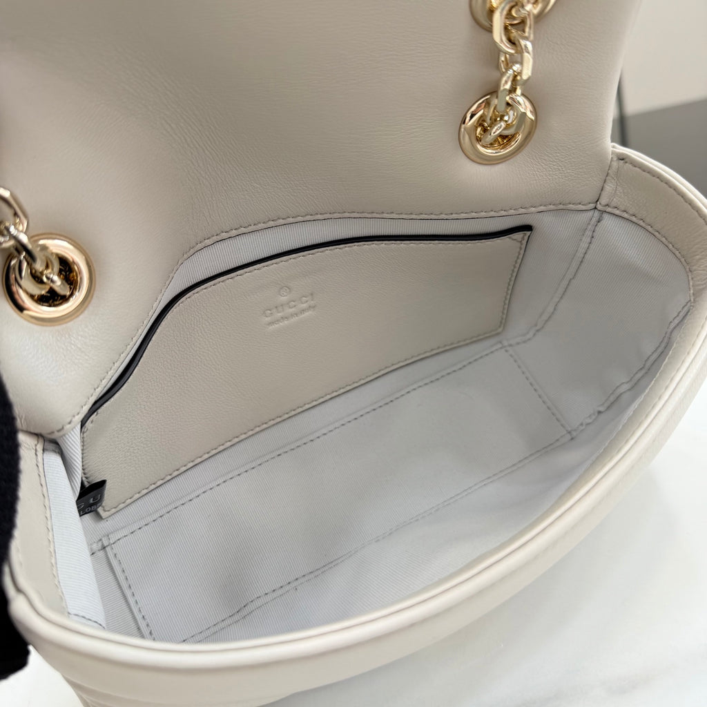 Off-white leather mini bag interior view with stitched lining and open top edge