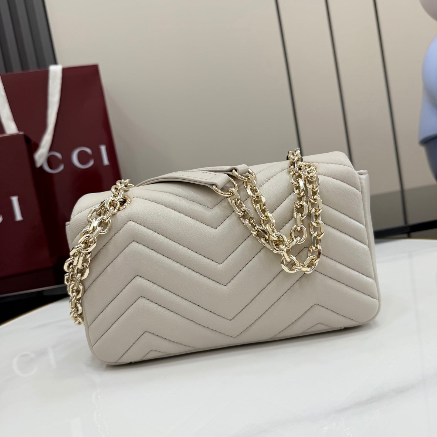 Off-white quilted leather shoulder bag with gold-tone chain and GG logo hardware detail