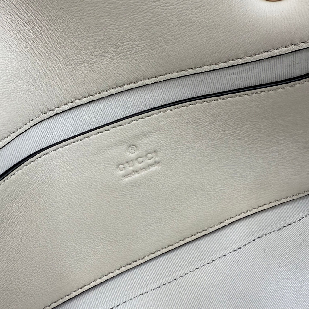 Gucci logo embossing on off-white leather lining inside the bag