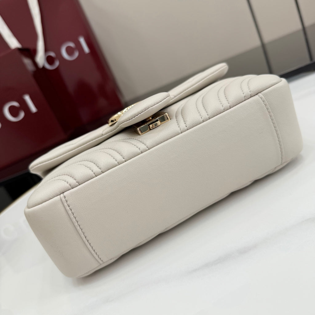 Off-white quilted leather shoulder bag back view with slim top handle and gold lock detail