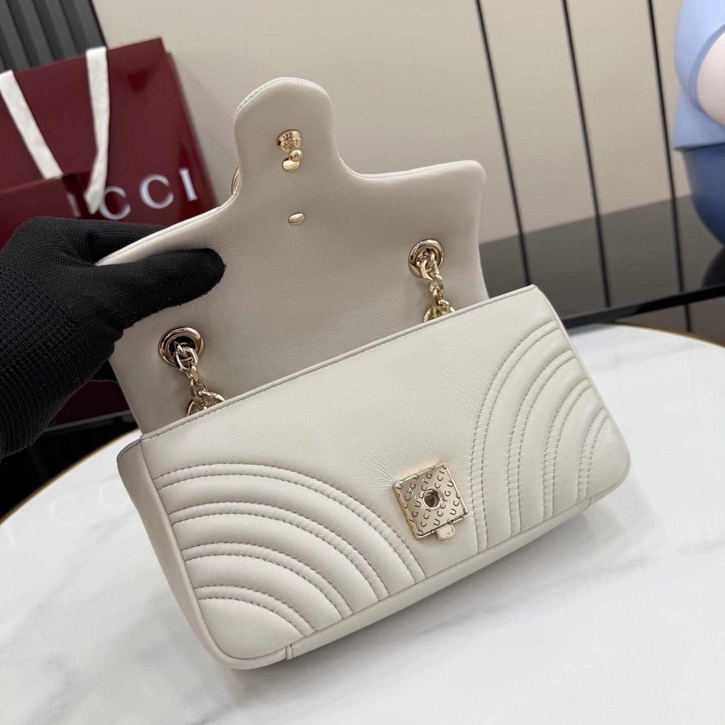 Off-white mini quilted leather bag with gold-tone chain strap and GG logo hardware