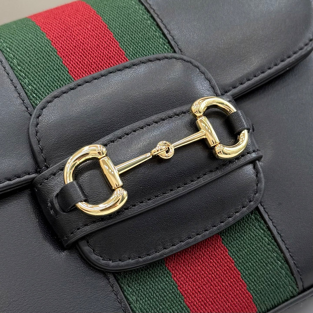 Gucci crossbody clasp detail on black leather flap with gold buckle hardware and green-red web stripe