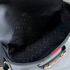 Gucci bag interior view with black jacquard fabric lining and contrasting green trim edge