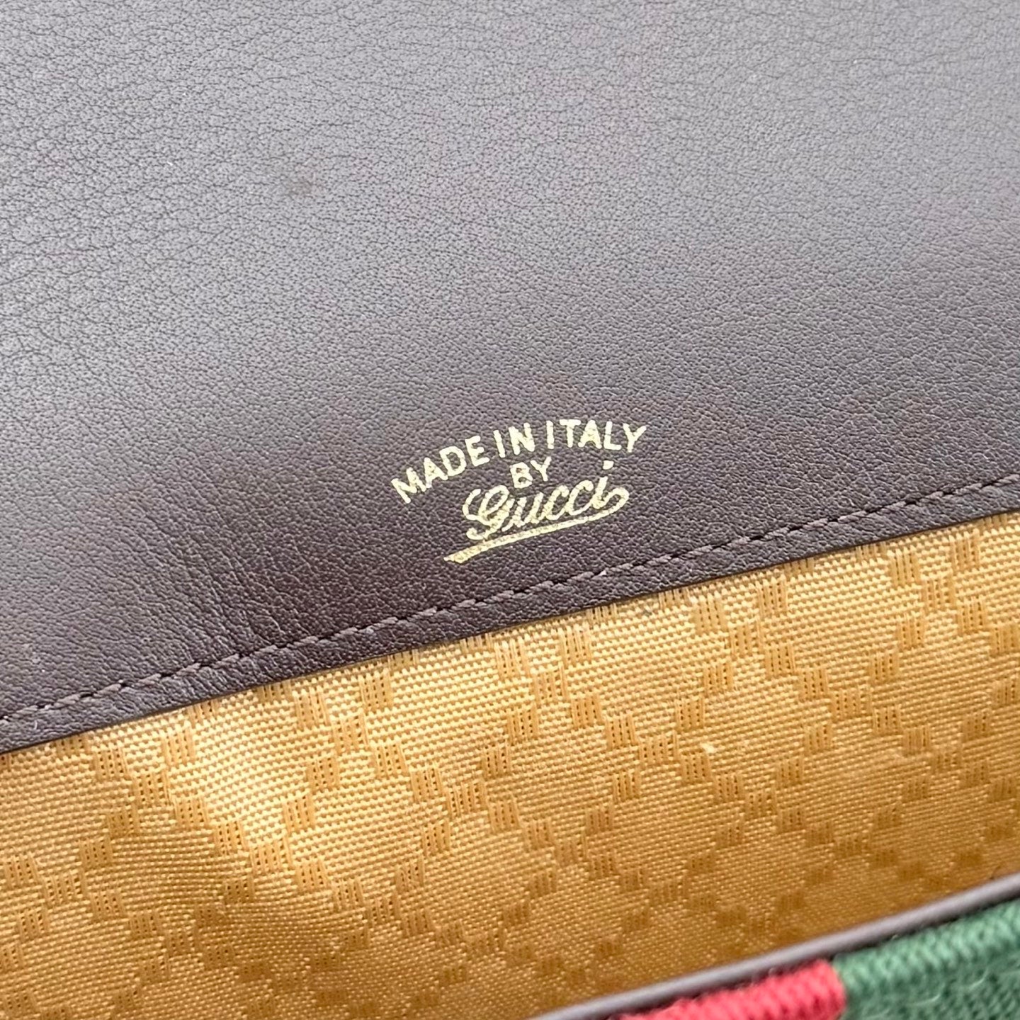 Close-up of Made in Italy Gucci on brown leather above tan lining