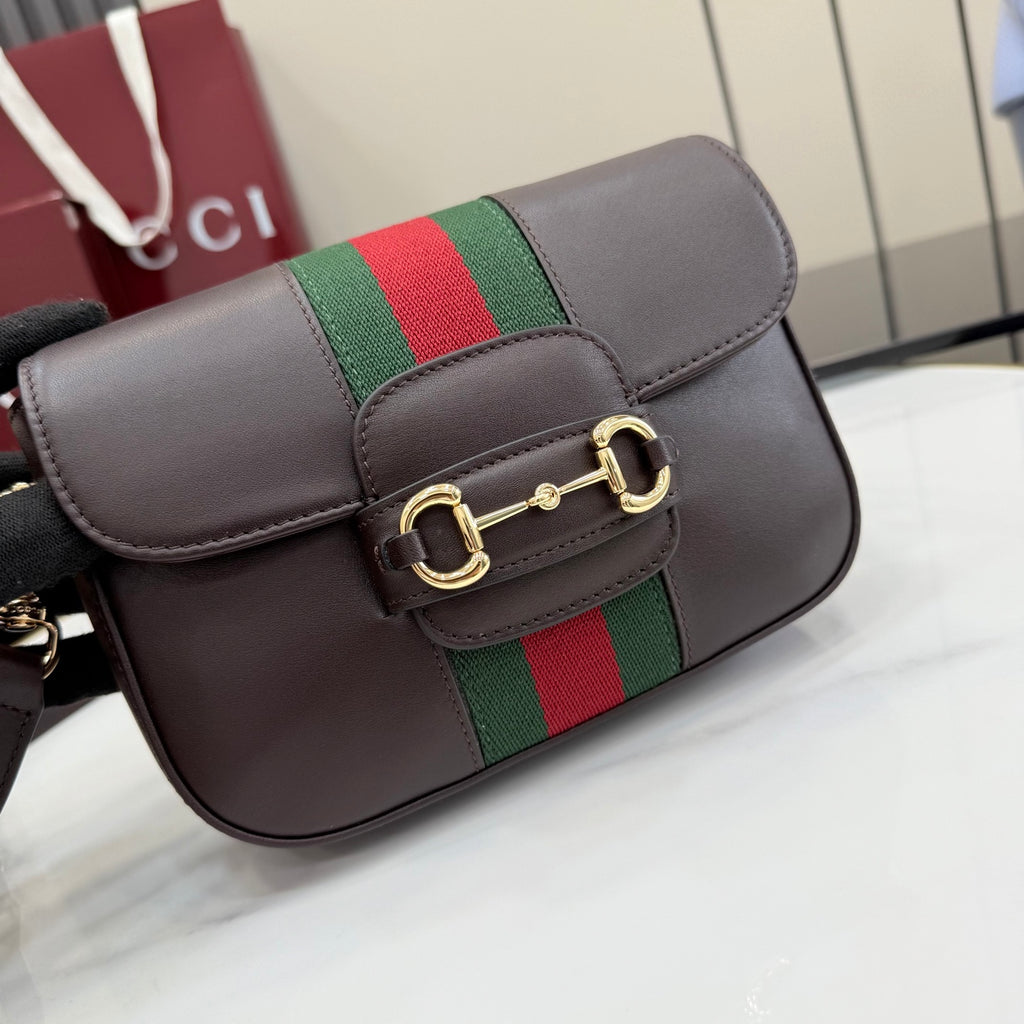 Dark brown leather crossbody bag with green and red stripe center and gold bar buckle