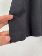 Black T-shirt fabric texture and hem stitching close-up