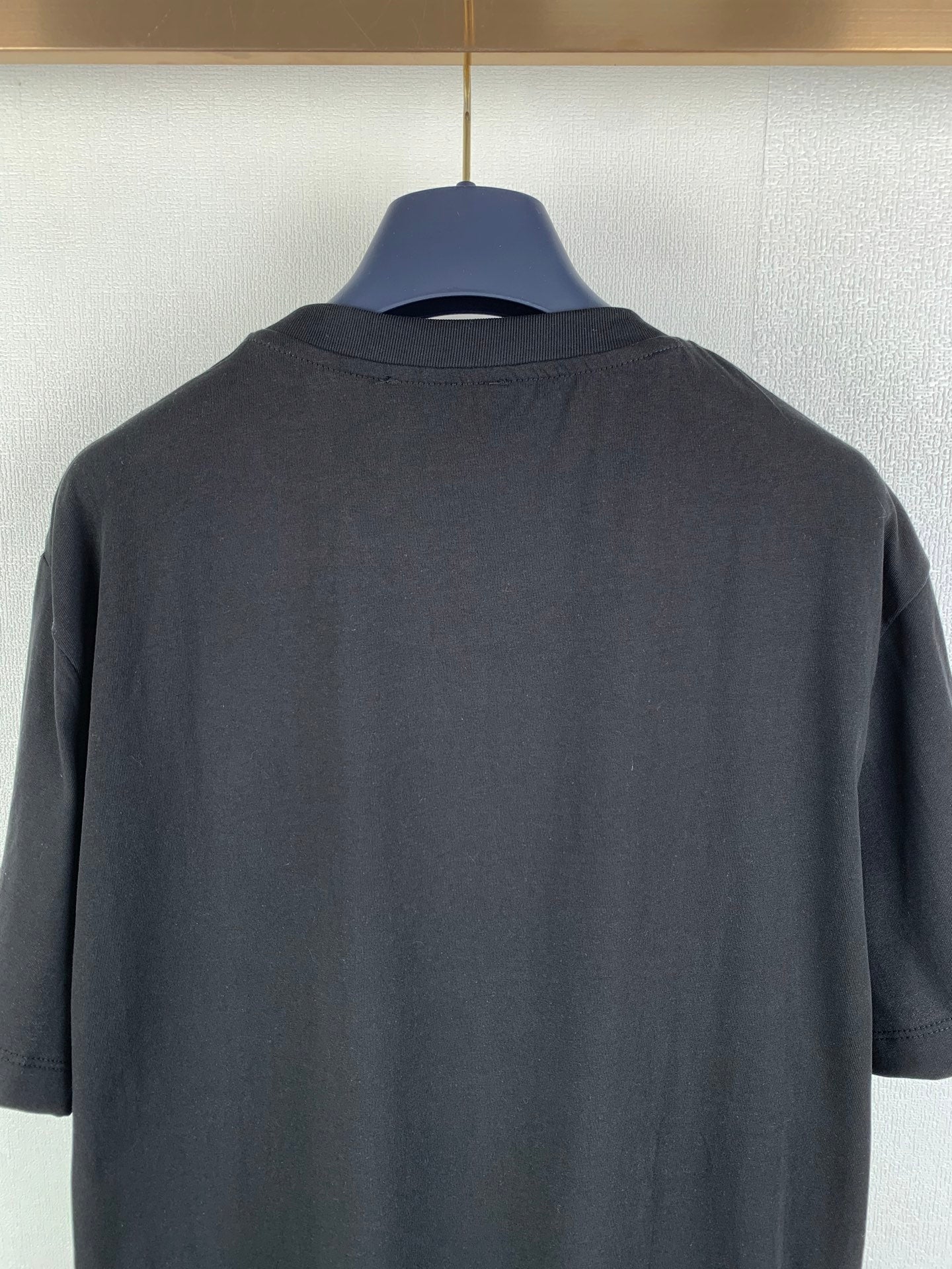 Black graphic T-shirt back view close-up of upper back fabric