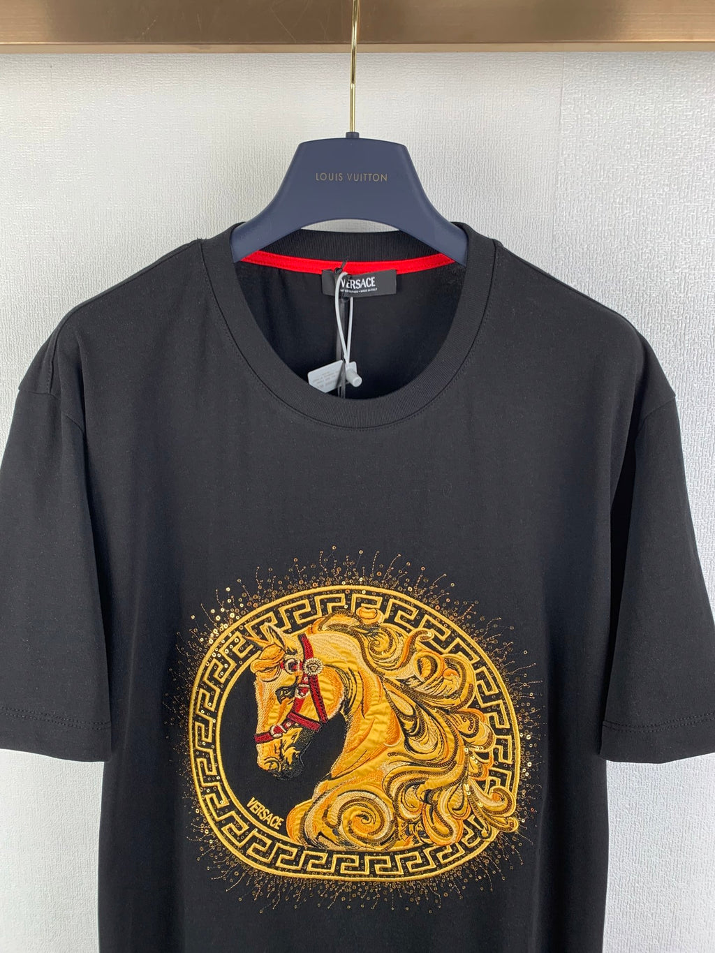 Black graphic T-shirt close-up showing horse emblem at the chest