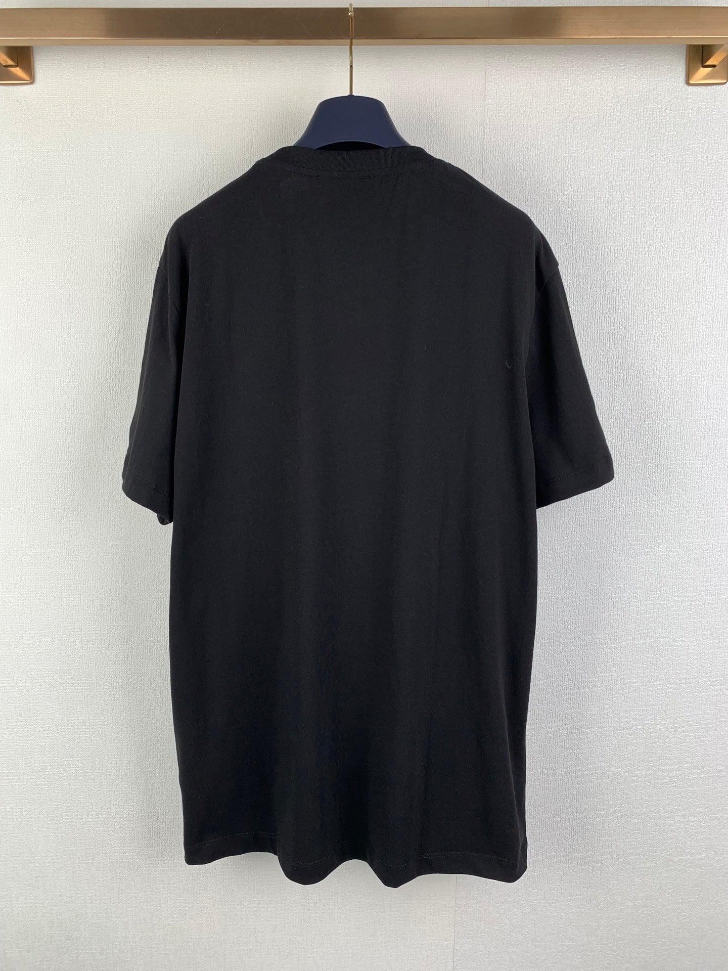 Black graphic T-shirt back view, plain with no visible front print