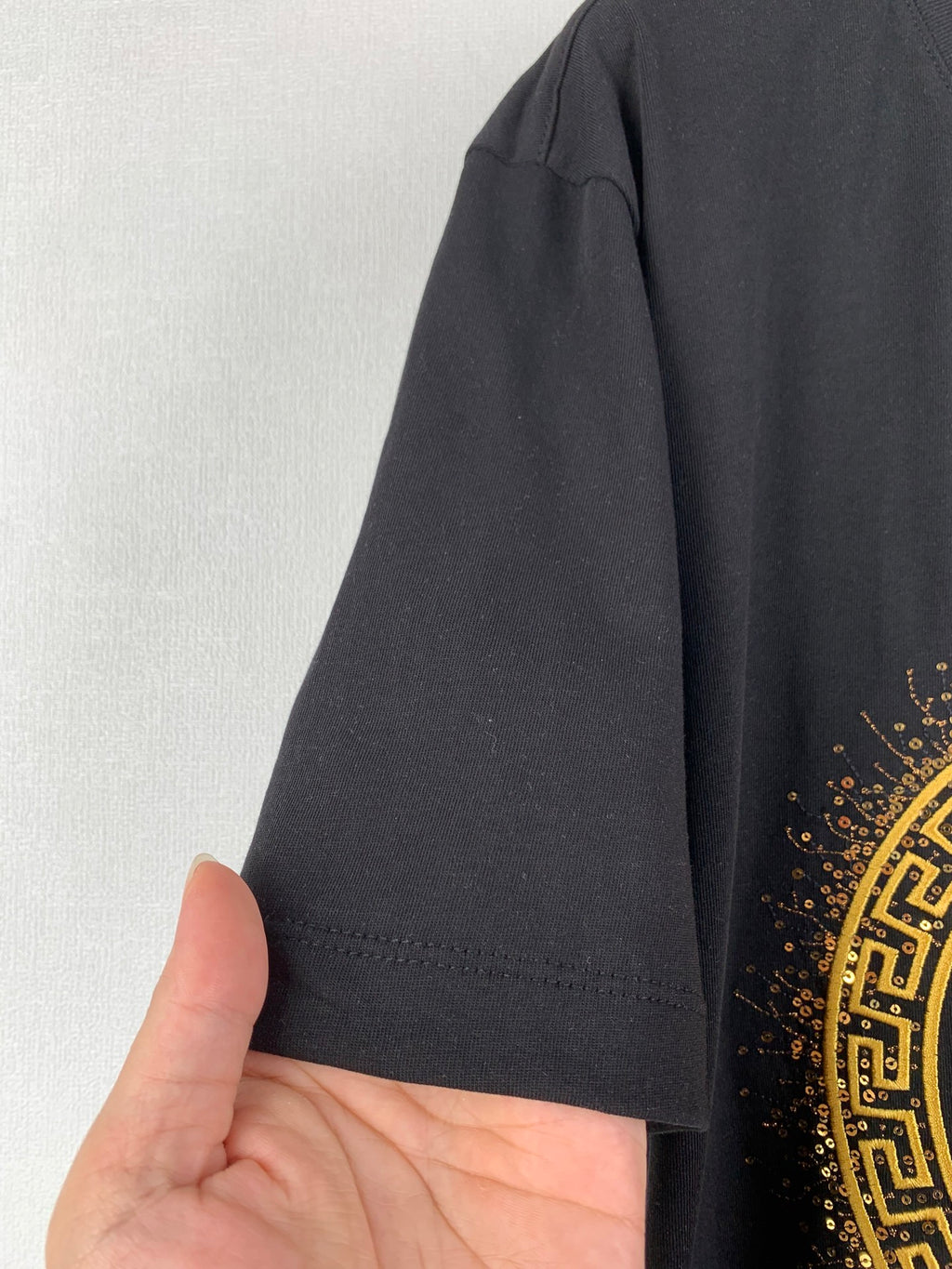 Black T-shirt sleeve and hem with fabric edge stitching