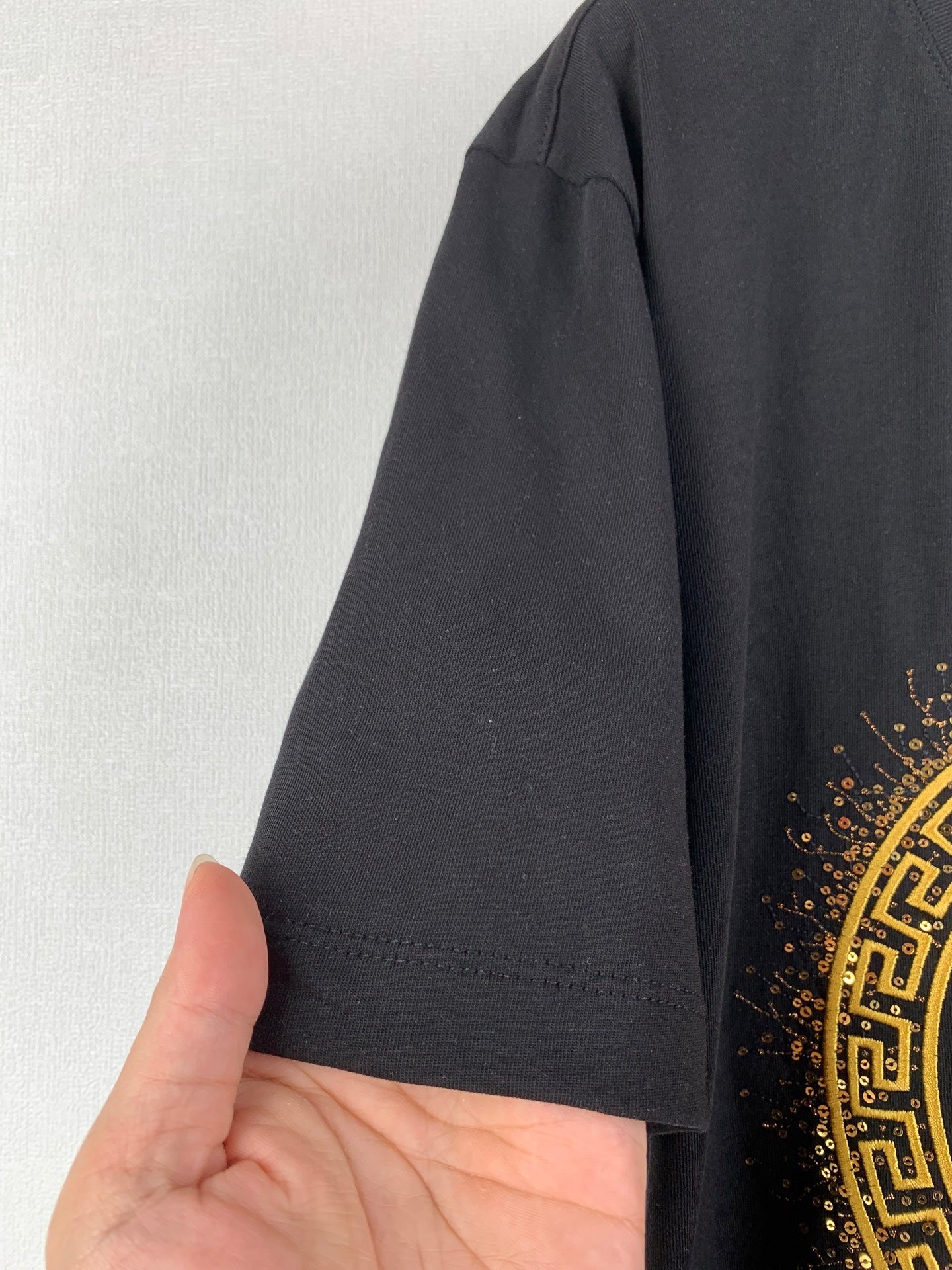 Black T-shirt sleeve and hem with fabric edge stitching