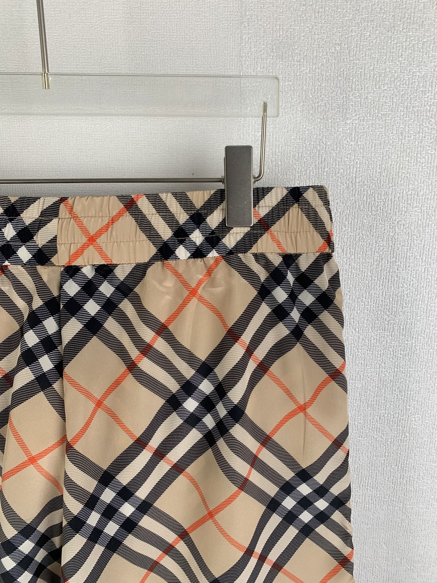 Burberry plaid pants waistband close-up with beige navy and red checks