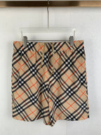 Burberry plaid pants with beige, navy, and red check pattern