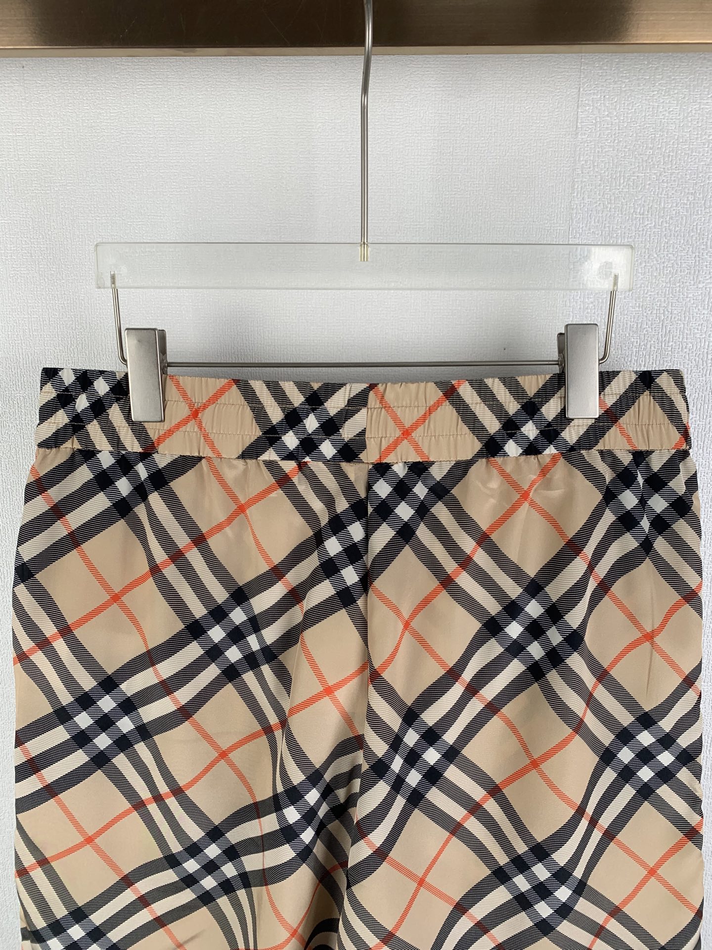 Burberry plaid pants front view with beige navy and red check pattern