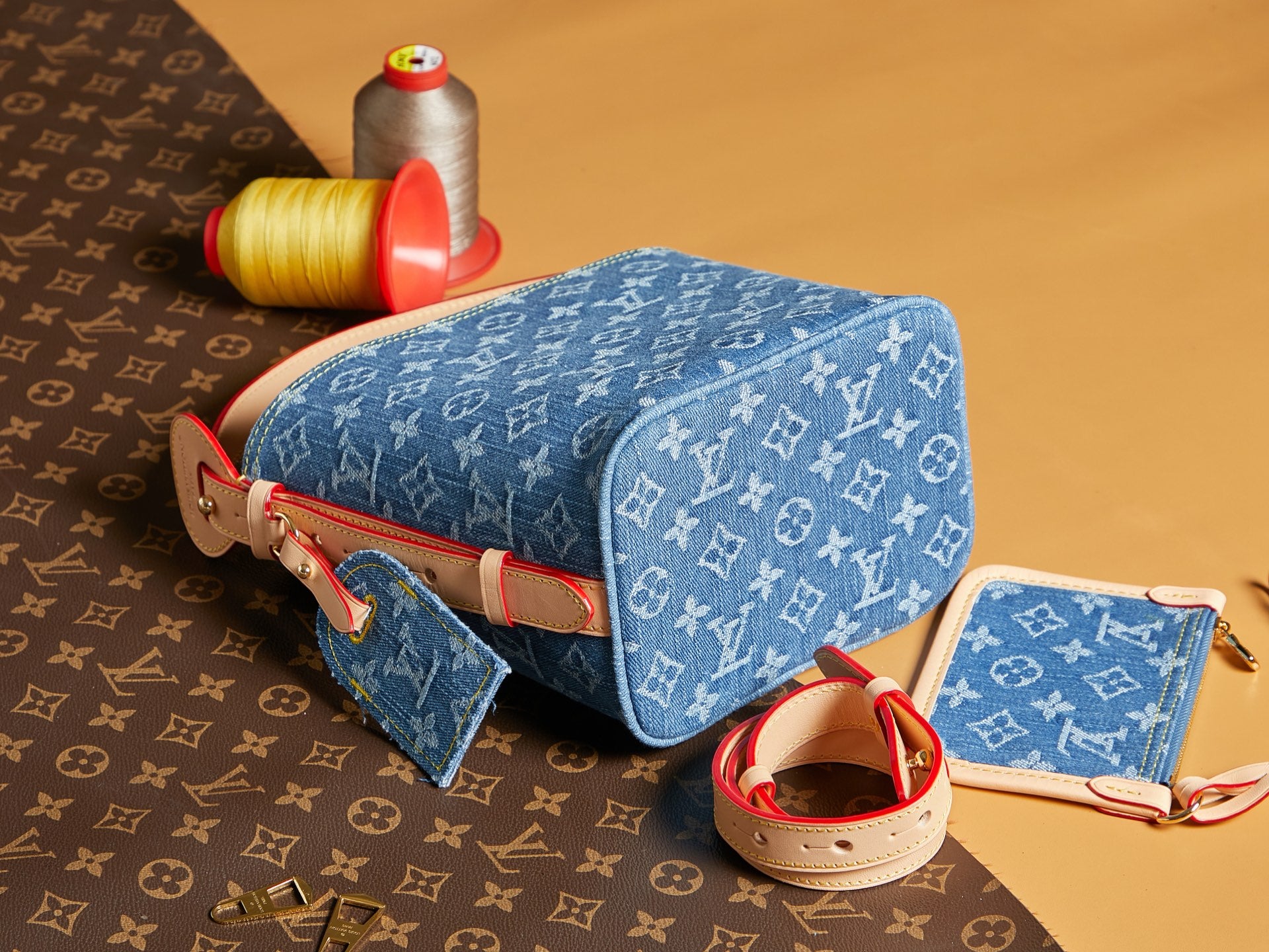 Blue monogram crossbody bag with red strap and zip top