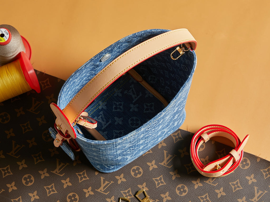 Blue monogram mini bag with curved top opening and red strap