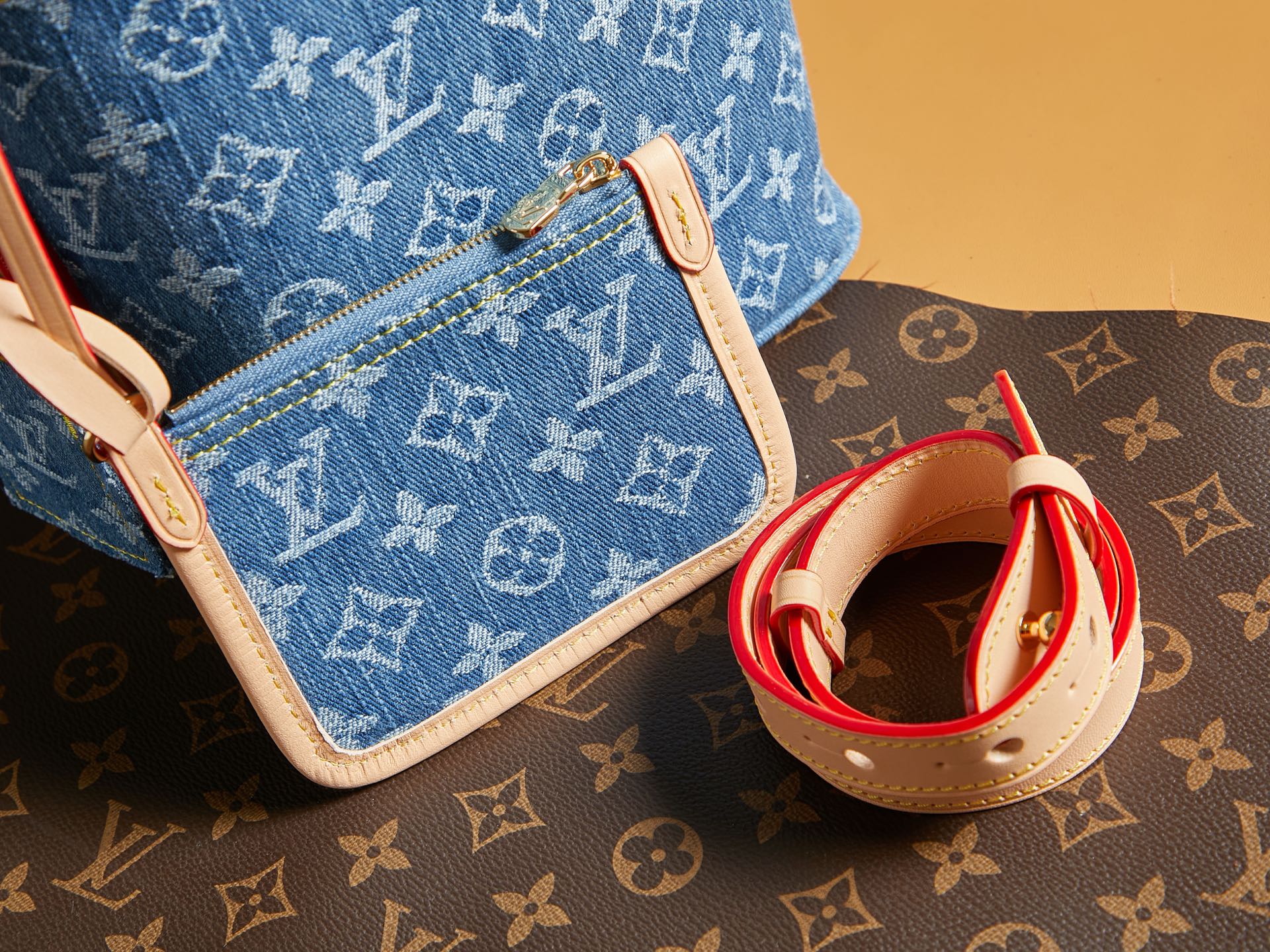 Blue monogram mini bag with white edge piping and red straps