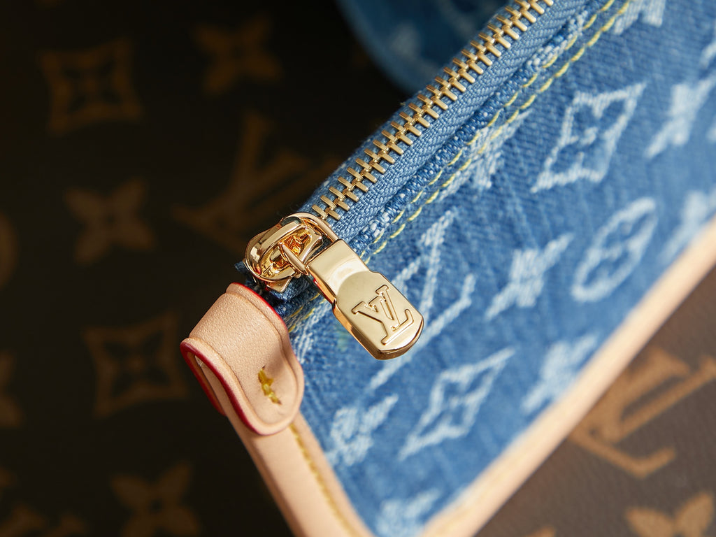 Gold zipper pull on blue monogram mini bag with red pull tab