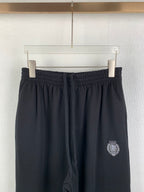 Balenciaga pants with elastic waistband and dark crest logo patch on thigh