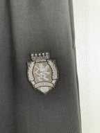 Balenciaga pants with embroidered crest logo patch on dark fabric