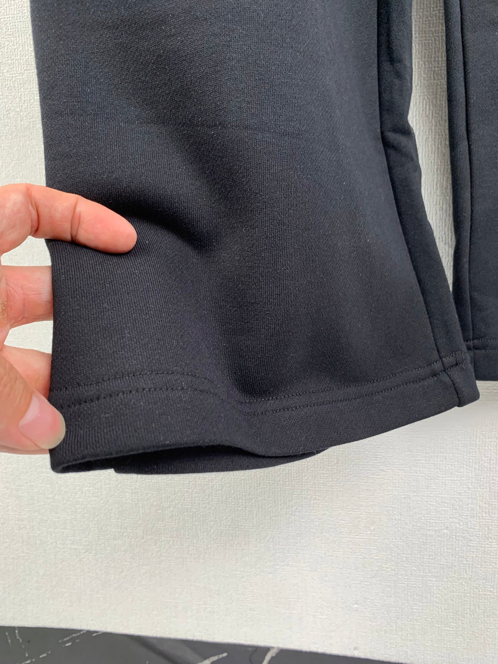 Balenciaga pants cuff hem with visible stitching on dark fabric